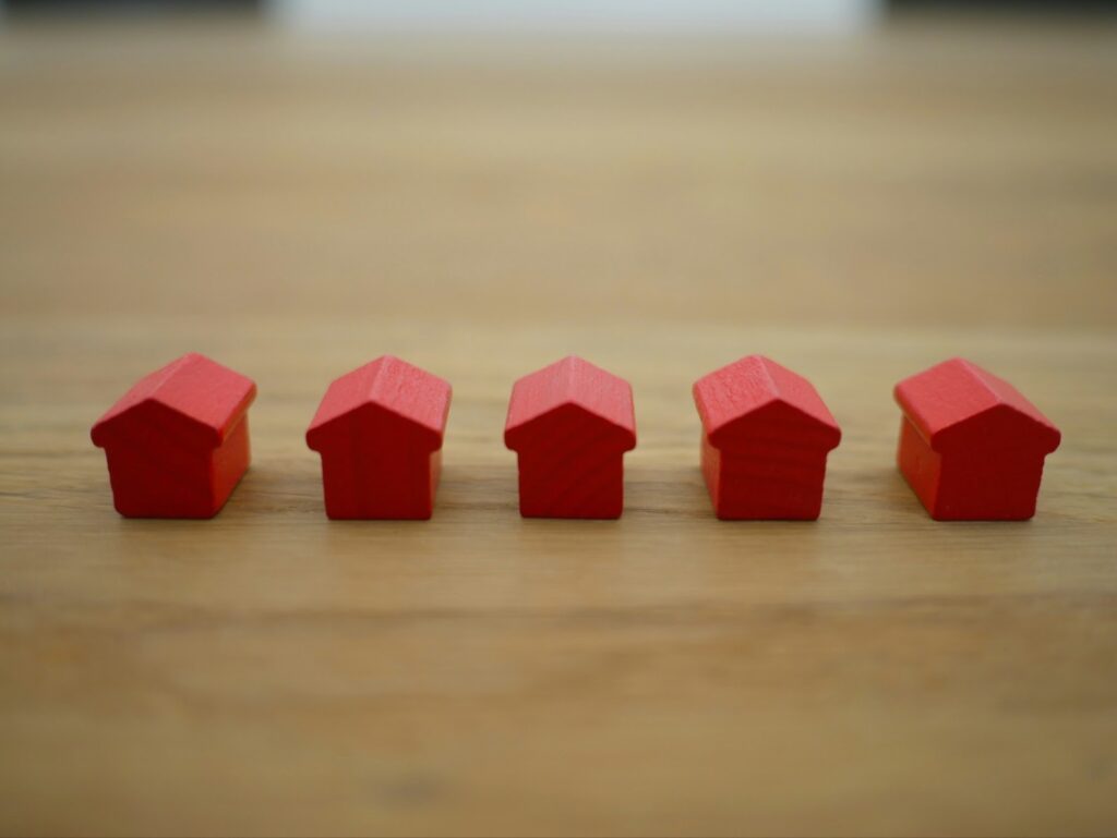 Red wooden houses, representing basic builds suitable for low-level homeowner insurance.