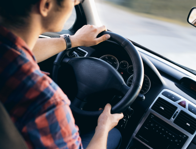 Close-up of a driver's hands securely on the steering wheel - displaying the careful work involved in last-mile deliveries.