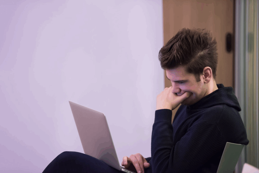 Someone sitting and looking at a laptop.