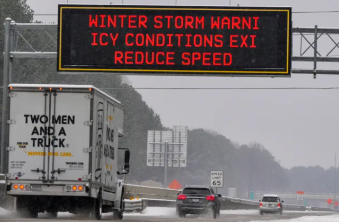An electronic highway sign warns of a winter storm and icy conditions - this is the kind of weather that makes the right snow plow insurance necessary