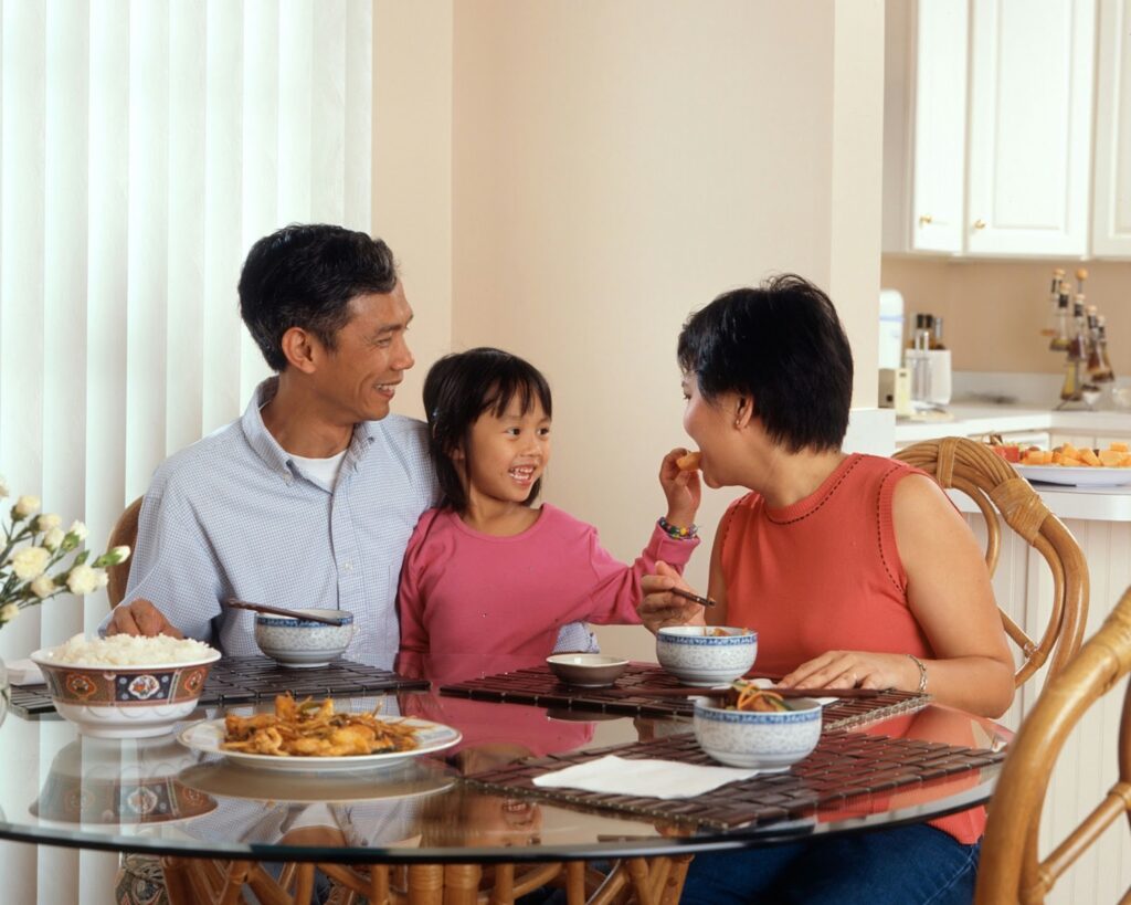 A family enjoying a meal together, having secured cost-effective family health insurance.