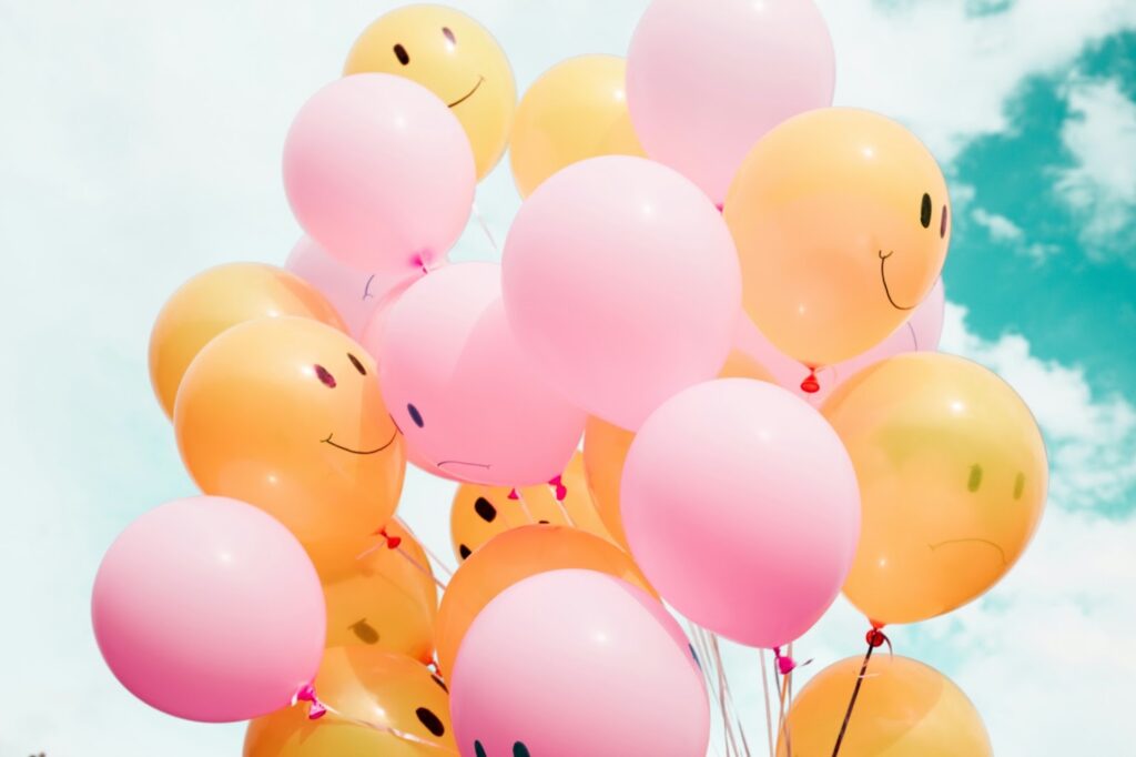 Smiling balloons, representing optimism bias that can drive up accident insurance costs.